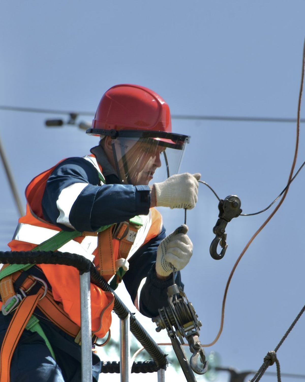 Dos tecnicos trabajando en una red electrica con equipo de seguridad.
